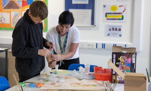 Staff and a student doing arts and crafts