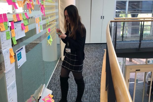 A typical day of a user researcher showing Lydia working on the User research wall in the office