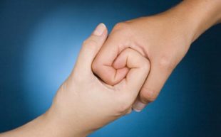 Two hands interlocked to suggest collective strength