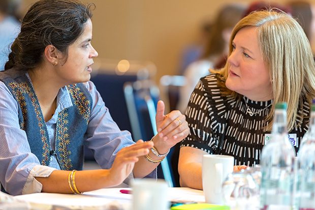 Rasmi and Collett talk at a table at the Digital Voices launch event in Manchester.