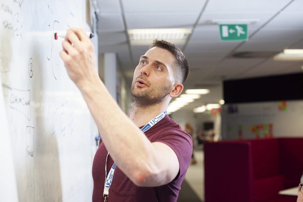 DWP business analyst writing on a whiteboard