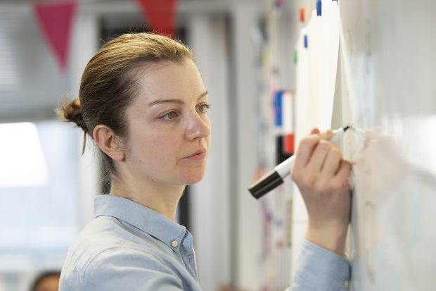 User researcher writing on a whiteboard