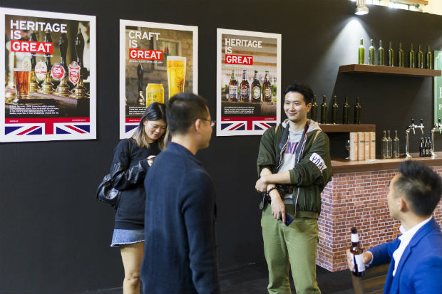 Chinese visitors at an event in Shanghai to promote UK food exports, with posters for the Britain is Great campaign in the background