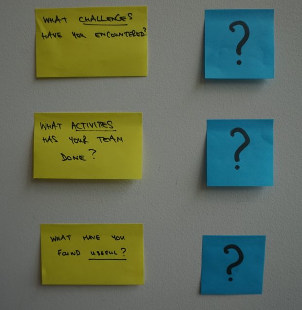 displaying three post-it notes with three questions: What challenges have you encountered?, What activities has your team done?, What you found useful?