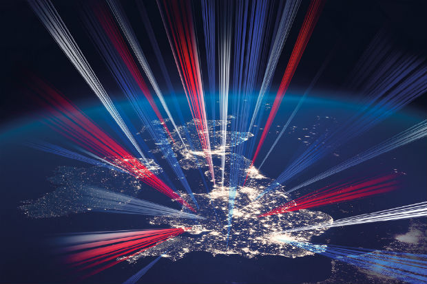 Image from space of the United Kingdom at night, showing light from major conurbations and with shafts of light in red, white and blue emanating from the land mass