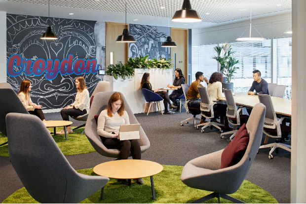 Interior view of workspace in the Government Hub in Croydon, South London, showing people working at desks and in meetings