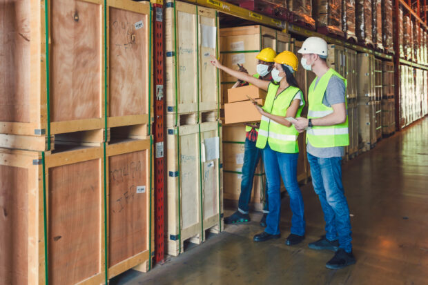Warehouse workers wearing face masks having a discussion