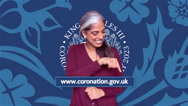 A BSL interpreter for the King’s Coronation 2023 points to a link for the coronation website.