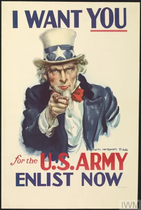 Uncle Sam in blue coat, red stock and star-decorated hat faces the viewer with a serious expression. He is pointing with his right hand at the viewer