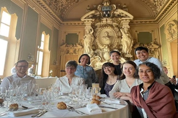 Group image of several people sat around a dinner table