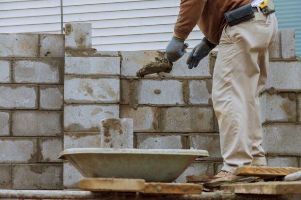 Man building a wall out of breeze blocks