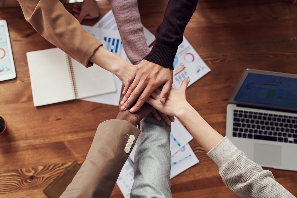 Image of crossed hands to depict teamwork