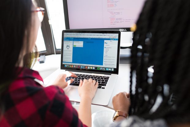 Photo of two apprentices sitting at a computer at the Home Office