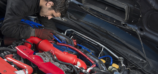 Mechanic looking under bonnet of modified car