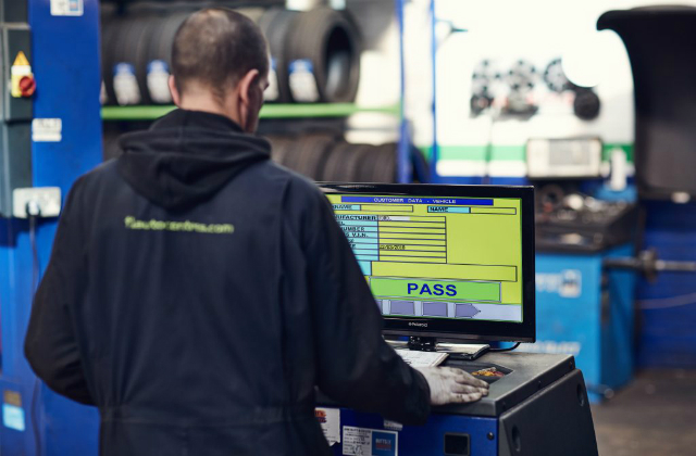 An MOT tester looking at a screen showing an MOT pass.