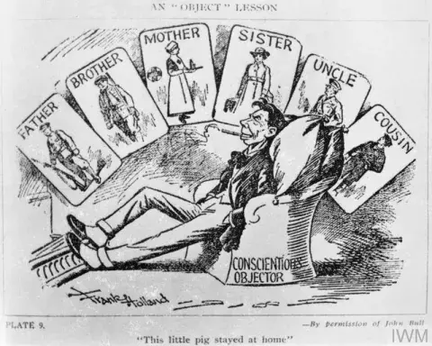 First World War cartoon depicting a conscientious objector in an arm chair while the rest of his family, shown above him on cards, contribute to the war effort.