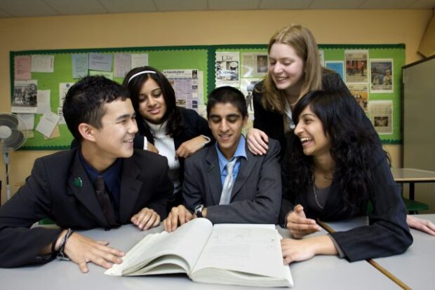 Children and teachers looking at a notebook