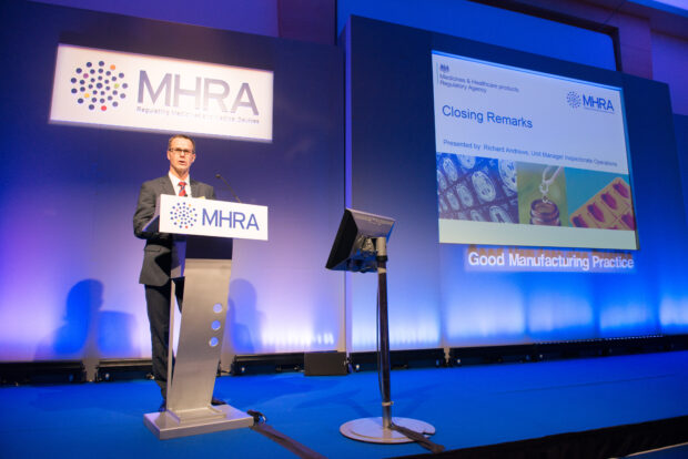 Presenter on stage at the GMP Symposium