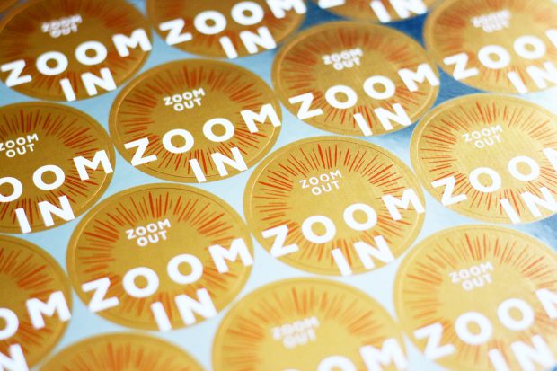 A sheet of yellow-golden stickers saying zoom out, zoom in made for participants of service design training