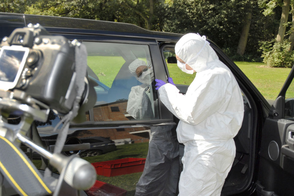Forensic analyst working on car