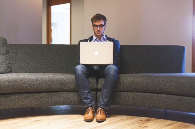 Entrepreneur sitting on a sofa and working on a laptop.
