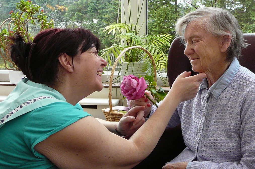 Care home carer smiling at resident