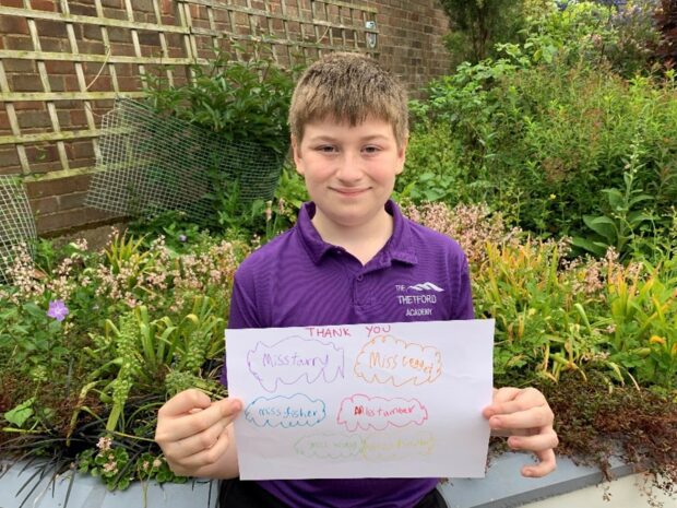 Mason holding a drawing saying 'thank you'