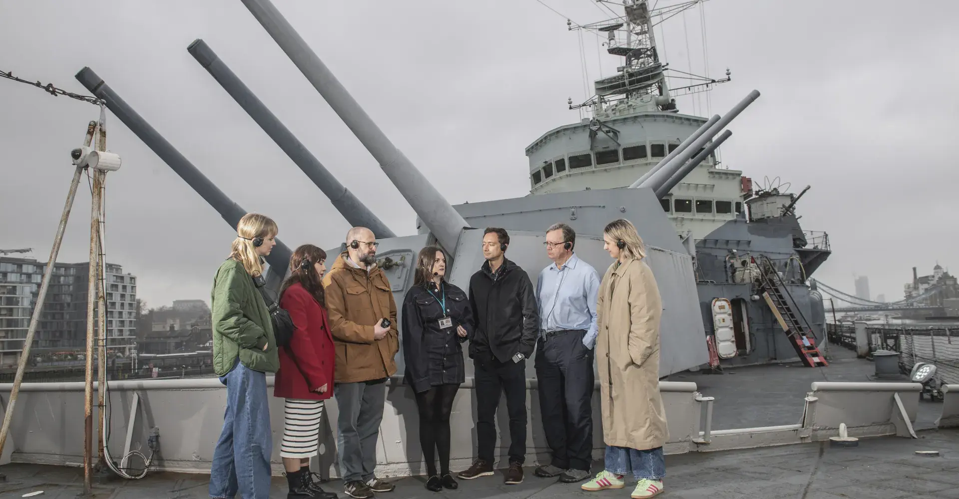 Guests attend a tour on the deck of HMS Belfast