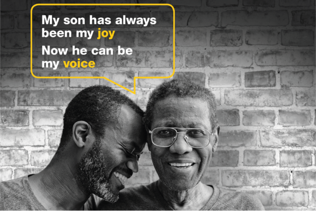 Two men hugging with a speech bubble above them that says 'My Son has always been my joy, now he can be my voice'