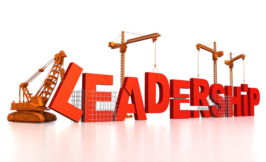 The word 'leadership' set out in 3D letters being set into place by cranes