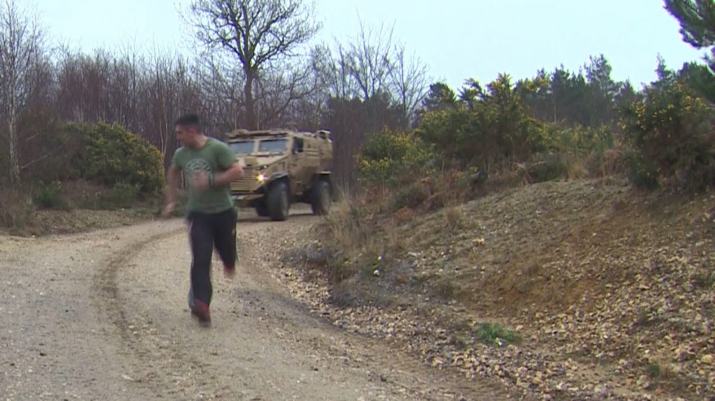 A runner is surprised by a Foxhound armoured vehicle when running on the training estate. [Crown Copyright, MOD]