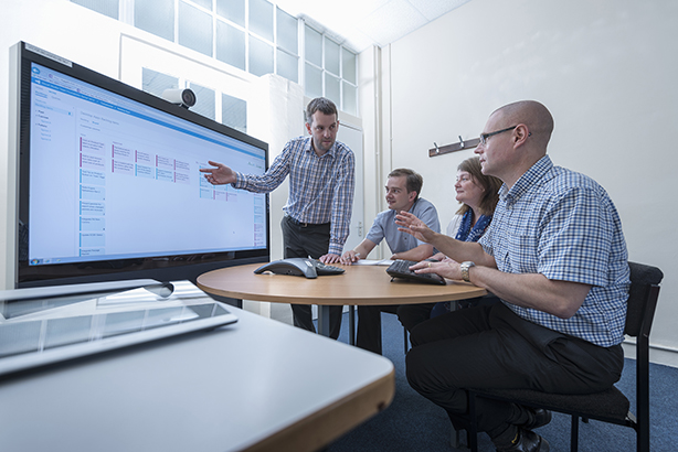 Software engineers holding a meeting around an interactives surface