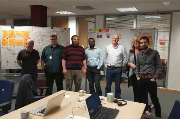 A picture of the current team in the Sheffield Hub, all standing and smiling