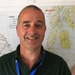 Photo of Iain Bell, APHA Veterinary Adviser in the Field Epidemiology Team, in front of some maps of Scotland