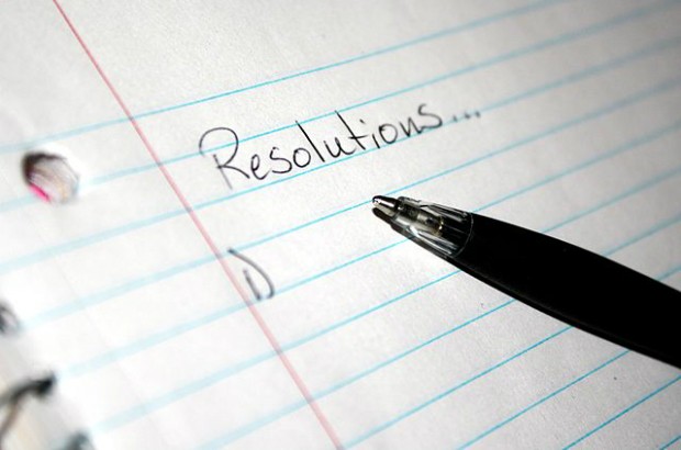 A lined paper notepad with the the word resolutions written on it.
