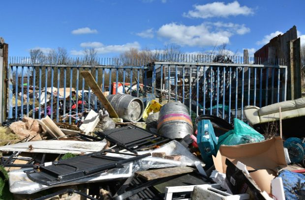 Discarded waste against a gate.