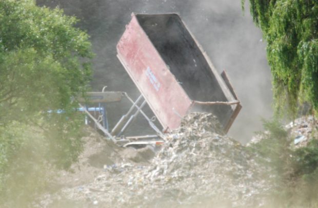A photo of a tipper lorry dumping waste illegally on private land