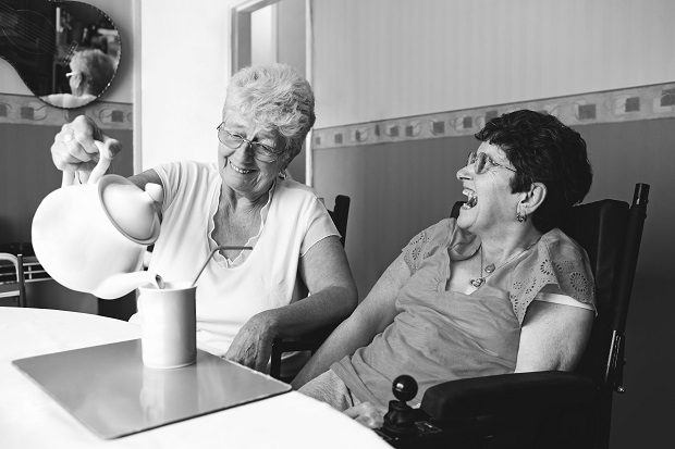 Two women laughing while having a cup of tea