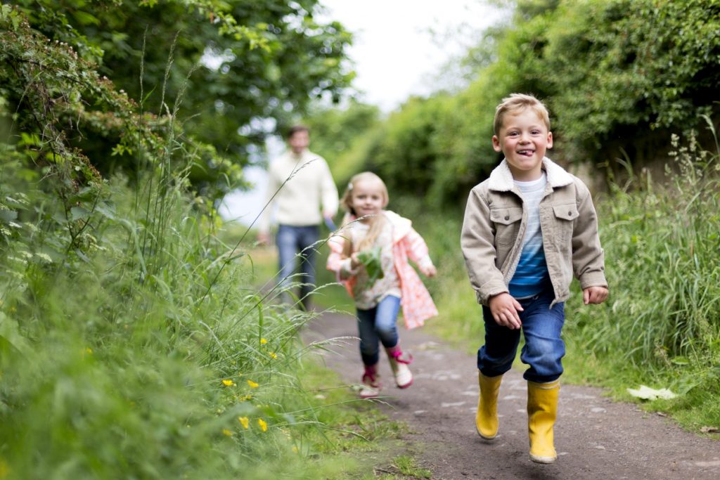 Children and their father going out for a walk.