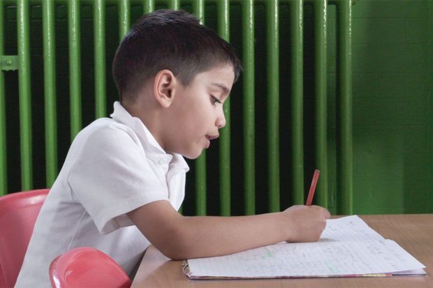child filling in work pages