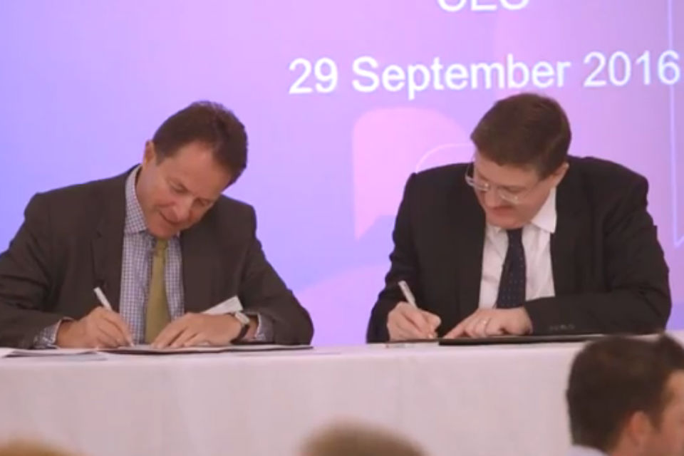 Two men signing documents