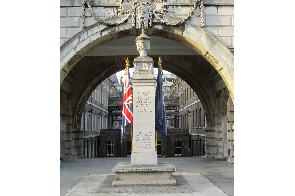 Memorial column, with urn atop, flanked by two flags, and arch, part of Somerset House, behind