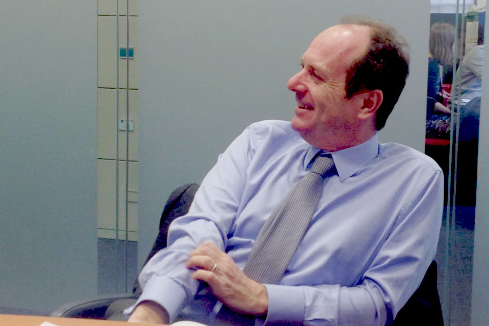 Bill Crothers answering questions in an office