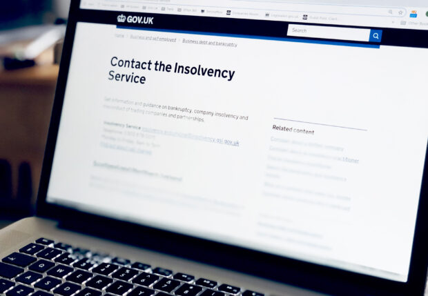 Laptop with 'contact the insolvency service' on the screen.