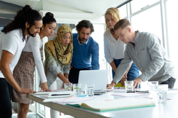 A diverse group of business people working together on laptop at conference room in a modern office.