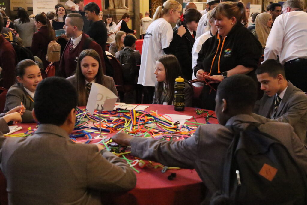 Volunteer smiling at table of boys and girls