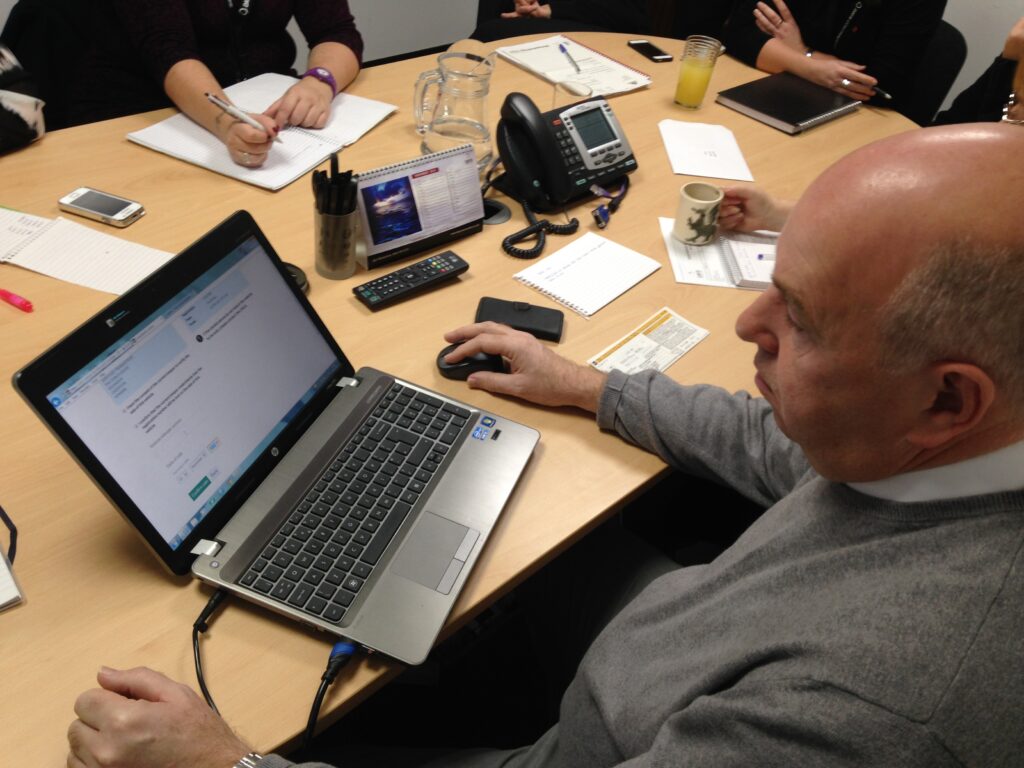 Man sitting at a a table using a laptop