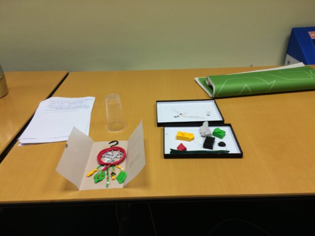 One of the 'ideal policy tools', similar to a Native American dreamcatcher, is complete on a table next to the box of modelling materials.