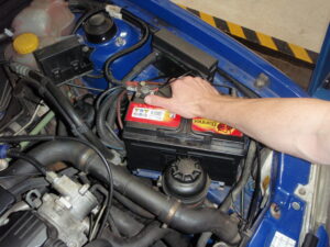 A garage mechanic looking under a car bonnet