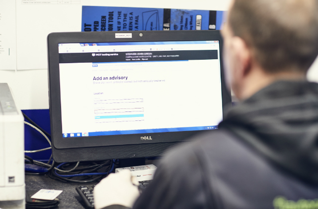 AN MOT tester looking at the advisories screen on the MOT testing service.
